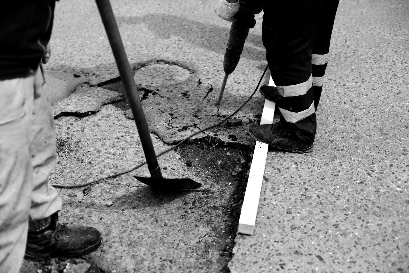 Crew applying crack filler and sealcoat to an asphalt parking lot surface