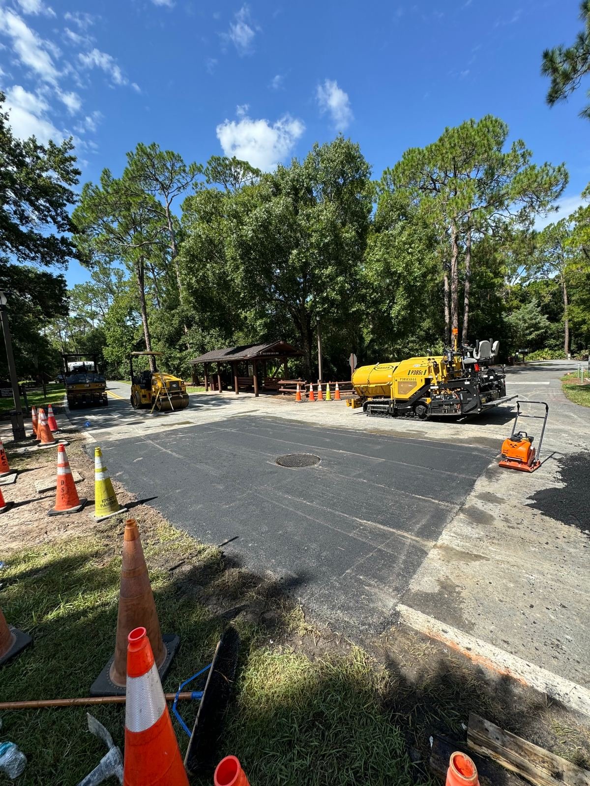 Specialty Paving crew laying new asphalt with a paver on a Tampa commercial site