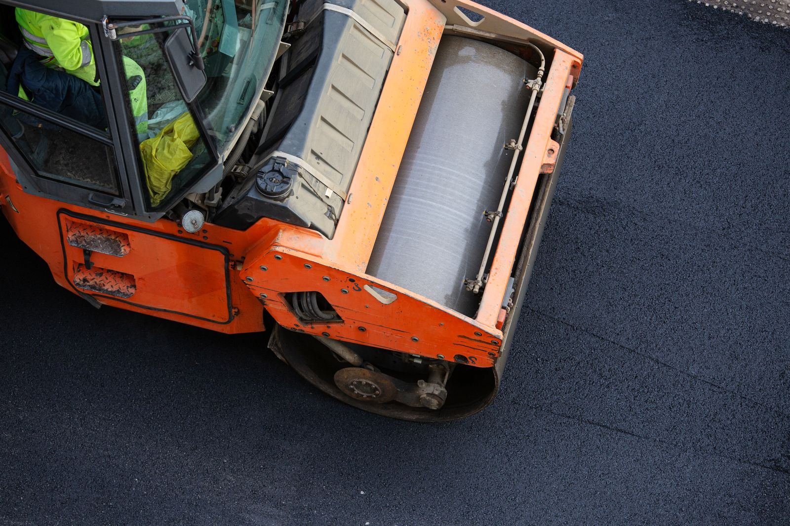 Asphalt roller compacting a freshly paved surface